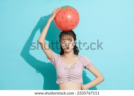 Portrait of young Asian woman in swimsuit on blue background