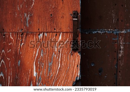 A rusty steel handle on a wooden panel