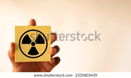 Attention symbol,Cautionary Warning,safety, hazard,danger concept.,Radiation hazard sign on yellow sticky note over white background with copyspace use for Nuclear,radioactive alert warning idea.