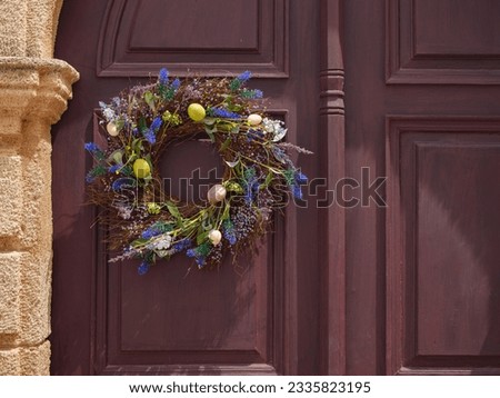 travel to city of Lindos on island of Rhodes, Greece. decoration for Easter, a wreath with flowers and Easter eggs on the door of the house