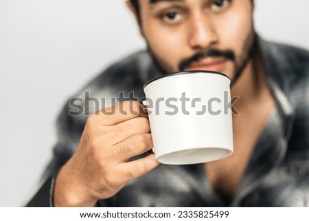 Professionally presented, the mockup showcases a man holding a white blank mug, adding elegance to your visual concepts