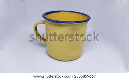 Yellow enamel cup isolated on white background 