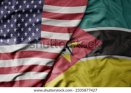 big waving colorful flag of united states of america and national flag of mozambique . macro
