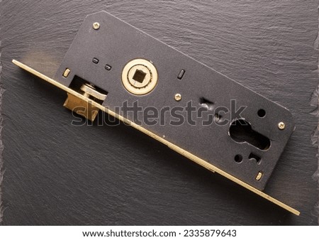 One mortise lock to a door on slate stone, close-up, top view. Royalty-Free Stock Photo #2335879643