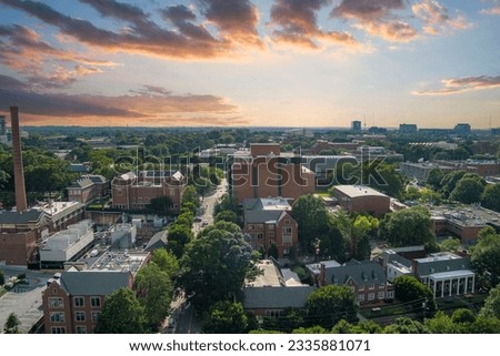 Atlanta, Georgia USA - 7 10 2023: aerial footage of red brick buildings with lush green trees and plants and office buildings in the city skyline at the Georgia Institute of Technology campus  Royalty-Free Stock Photo #2335881071