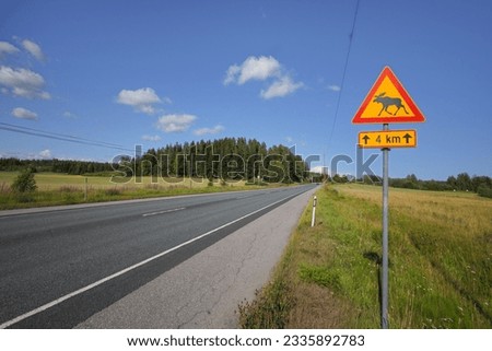 A road sign "Caution moose" on a country road in Finland Royalty-Free Stock Photo #2335892783