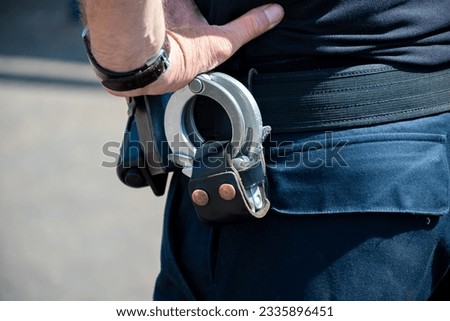 Police officer, policeman with handcluffs on belt, clime prevention, close-up Royalty-Free Stock Photo #2335896451