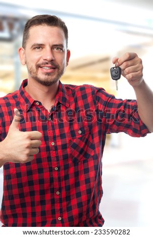 Man with red shirt over shopping center background. Showing a car keys