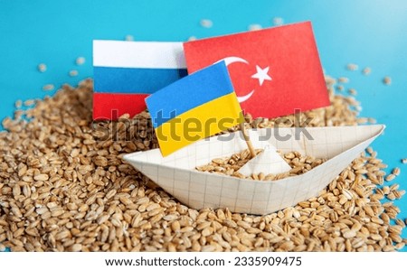 Ukrainian ship grain wheat, Turkey and Russia flags background. Grain deal and problem of blockade of ports, grain corridor, Ukraine Russia conflict. Royalty-Free Stock Photo #2335909475
