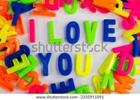 This stock image shows the words "I love you" made from colorful letter magnets on a plain background.