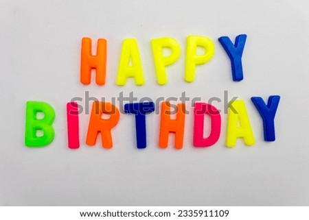 This stock image features the words "Happy Birthday" made from colorful letter magnets on a plain background.