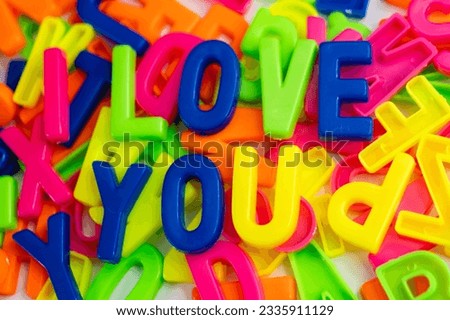 This stock image shows the words "I love you" made from colorful letter magnets on a plain background.