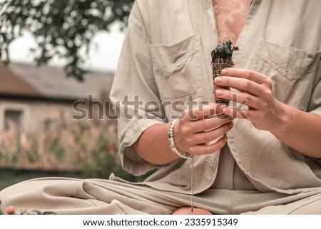 Woman Inhaling Incense Smoke During Meditation
Ground level of relaxed female meditating and breathing while sitting in Lotus pose near fragrant incense during yoga session in garden
