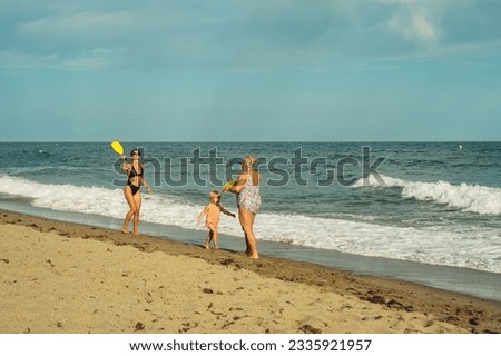 mother and daughter play mat cat on the beach in the summer afte