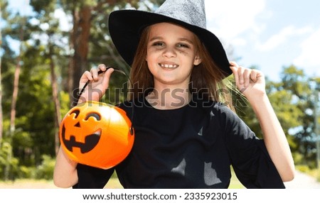 happy laughing child girl. little girl in halloween witch costume with pumpkin jack