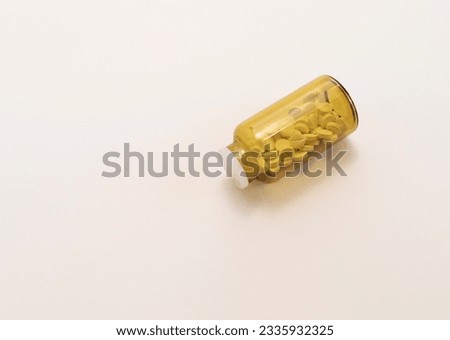 Top View Lying Glass Brown Bottle With Medication, White Pills Or Vitamins Beige Background. Horizontal Flat Lay. Copy Space For Text. Healthy Bio Supplements. Pharmacology. Design Or Mockup. Royalty-Free Stock Photo #2335932325