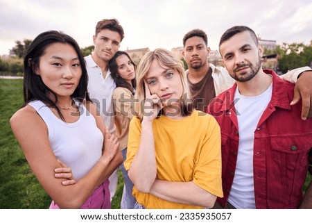 Taking life very seriously. Group of casually dressed young adults looking serious at the camera outdoors. Focused students unsmiling. They are confident in their field of work. Royalty-Free Stock Photo #2335935057