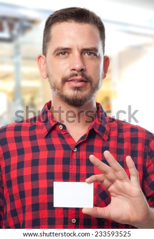 Man with red shirt over shopping center background. Showing a white business card