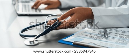 Doctor with stethoscope carefully review detailed medical report with laptop and diagnosing illness for effective healthcare treatment plan for patient in hospital doctor's office. Neoteric