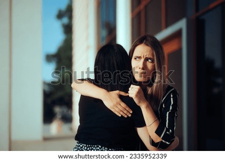 
Envious Woman Hugging Her Friend Feeling Skeptical. Fake friends not trusting each other feeling betrayed 
 Royalty-Free Stock Photo #2335952339