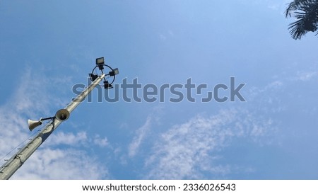 A very high light tower with clear blue sky in the background 