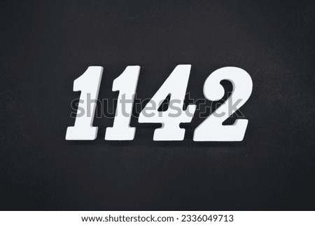 Black for the background. The number 1142 is made of white painted wood.