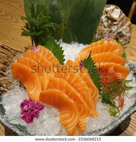 Salmon Sashimi set with fresh wasabi adding red seawood and green shi so and yellow flower Royalty-Free Stock Photo #2336068215