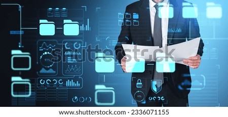 Businessman studying documents in hands, digital dashboard with files managing system and data protection. Concept of online database, digital indicators and cybersecurity
