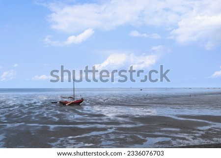 ship fallen dry on the mudflat of Wadden Sea tidal area in Harlingen, Friesland, the Netherlands Royalty-Free Stock Photo #2336076703