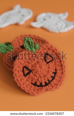 Flat crochet Halloween pumpkins on an orange background. Handmade Halloween decor.