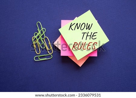 Know the rules symbol. Yellow steaky note with paper clips with words Know the rules. Beautiful deep blue background. Business and Know the rules concept. Copy space. Conceptual