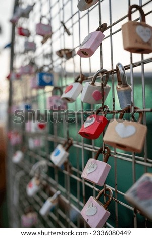 Locked padlocks on a fence with heart symbols