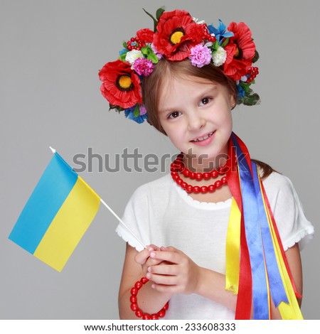 Young pretty girl in a ukrainian national costume on a light background