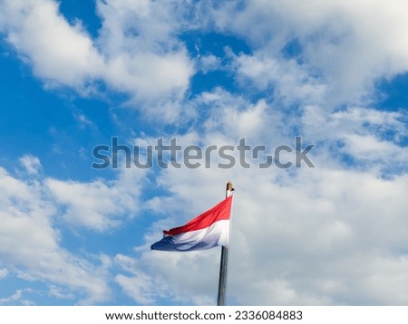Indonesian flag with blue sky as a background, photographed horizontally