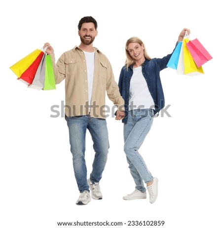 Family shopping. Happy couple with many colorful bags holding hands on white background