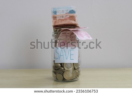 the inscription save with the iron and paper money in the jar. financial growth or money saving concept. 