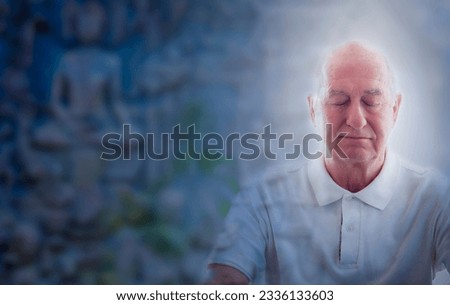 senior man peacefully meditates, eyes closed, amidst the blurred backdrop of a stone relief Buddha figure. He exudes wisdom and tranquillity, embracing the art's ancient spirituality.  Royalty-Free Stock Photo #2336133603