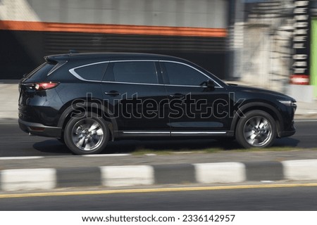 A black SUV car speeding on the highway Royalty-Free Stock Photo #2336142957