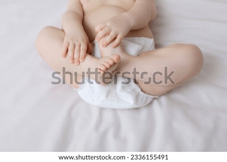 Little baby in diaper lying on bed, closeup