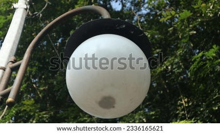 street lighting with white bulbs and large round shapes hanging from poles