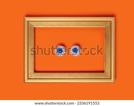 Scary and funny framed eyes on orange background for Halloween, holidays, decorations and party concept for Halloween