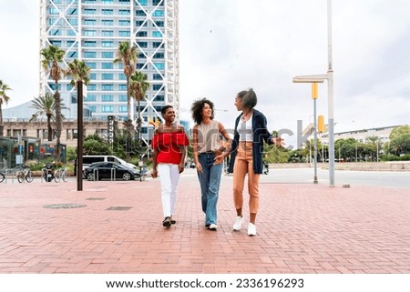 Happy beautiful hispanic south american and black women meeting outdoors and having fun - Black adult females friends spending time together and walking in the city for shopping