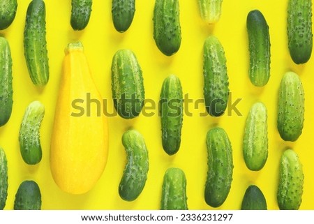 Freshly picked vegetables, zucchini and cucumbers on a yellow background, top view