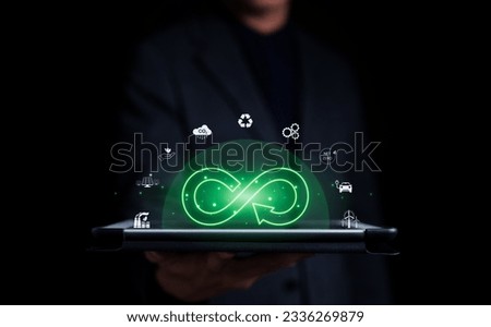 Businessman holding tablet with infinity symbol with circle economic environment icon floating and green light. Future sustainable investment growth, Reduce environmental pollution, sustainable energy