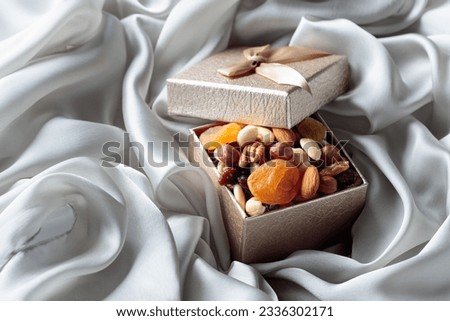 Dried fruits and nuts in a gift box on a grey cloth.