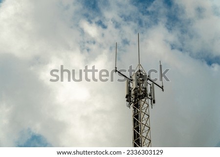 Telephone antenna against cloudy blue sky Royalty-Free Stock Photo #2336303129