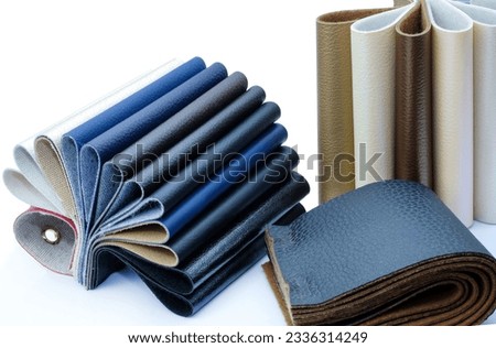 Various colors and types of leather for sewing furniture. Samples of leatherette on a white background. Catalog of samples of artificial leather. 