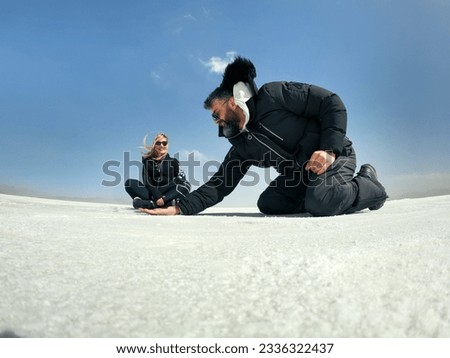 A couple plays with perspective in Salinas grandes, Jujuy Royalty-Free Stock Photo #2336322437