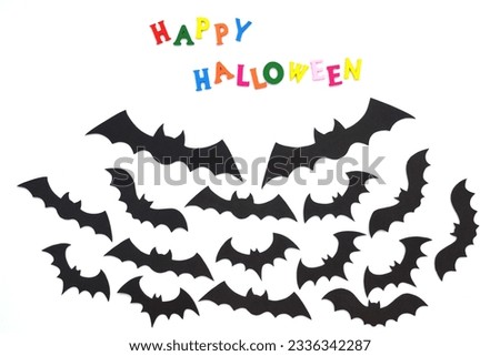 Halloween bats. Black bats and text in colored letters on a white background. Top view. Happy Halloween text concept.