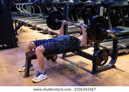 Young man doing bench press. Young man working out at the gym, chest day. Royalty-Free Stock Photo #2336342367